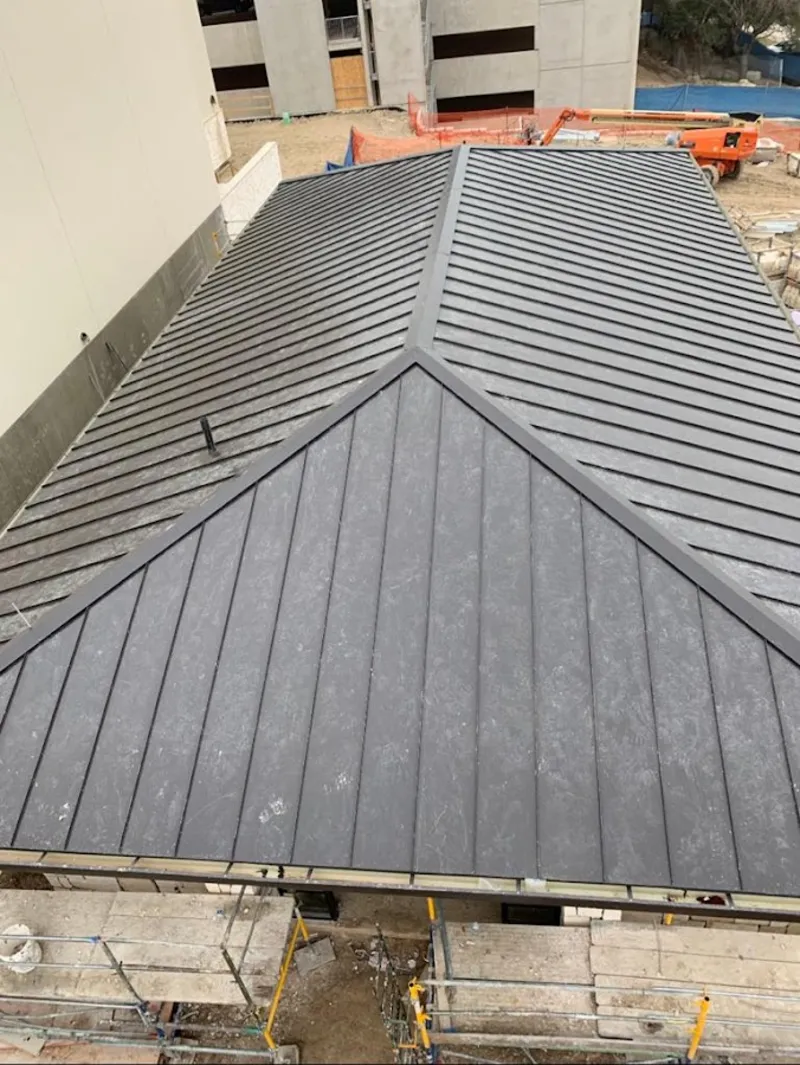 Commercial metal roof construction with crane equipment in Johnstown